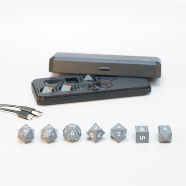 Set of 7 lit Hematite Grey dice with a rainbow of colors across all faces. Set Includes: 2 D20, 1 D12, 1 D10, 1 D8, 1 D6, 1 D4. Hematite Grey colorway is a fully opaque medium tone silver resin packed with rainbow glitter of various sizes. The numbers or symbols are painted pale white.
