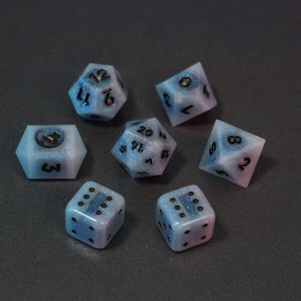 Set of 7 lit Aurora Sky dice with a rainbow of colors across all faces. Set Includes: 1 D20, 1 D12, 1 D10, 1 D8, 2 Pipped D6, 1 D4. Aurora Sky colorway is a mostly translucent white resin base packed with small blue and silver glitter throughout. The numbers or symbols are painted metallic black.