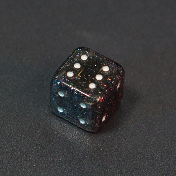 Collage of 7 lit Midnight Galaxy Pipped D6 with a rainbow of colors across each face. Midnight Galaxy colorway is a mostly translucent dark smoke black resin base packed with rainbow glitter of various sizes. The numbers or symbols are painted pearl white.