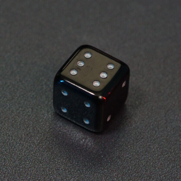 Collage of 7 lit Onyx Black Pipped D6 with a rainbow of colors across each face. Onyx Black colorway is a fully opaque black with no glitter, creating an almost matte style. The numbers or symbols are pale white.