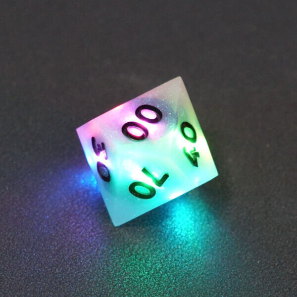 Collage of 7 lit Aurora Sky D00 with a rainbow of colors across each face. Aurora Sky colorway is a mostly translucent white resin base packed with small blue and silver glitter throughout. The numbers or symbols are painted metallic black.