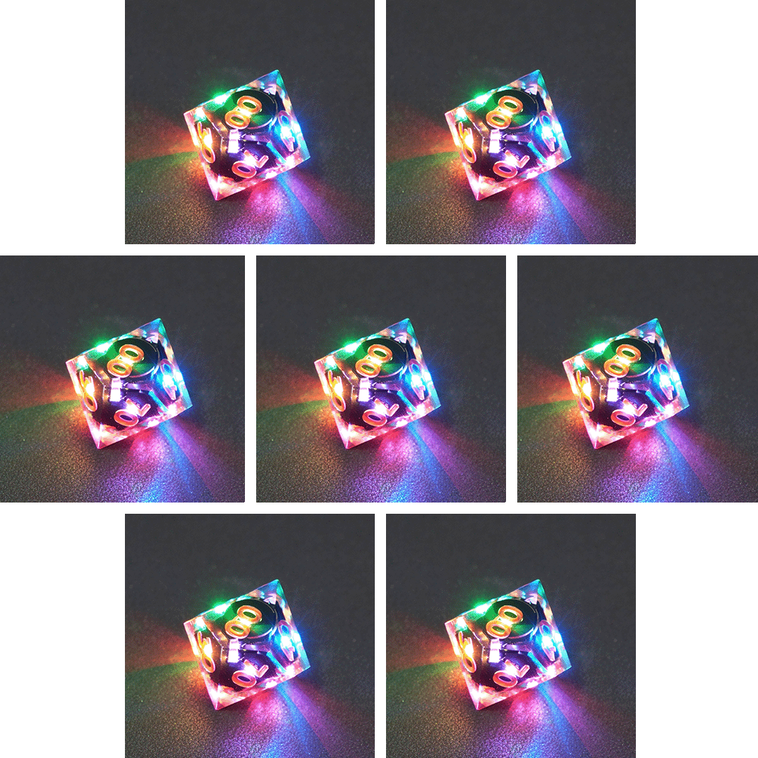 Collage of 7 lit Clear D00 with a rainbow of colors across each face. Clear colorway is fully transparent resin allowing internal circuit board to be visible. The numbers or symbols are painted metallic copper.