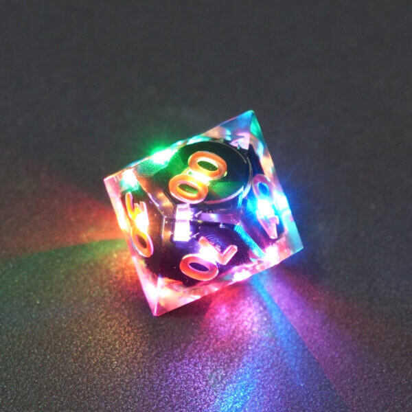 Collage of 7 lit Clear D00 with a rainbow of colors across each face. Clear colorway is fully transparent resin allowing internal circuit board to be visible. The numbers or symbols are painted metallic copper.