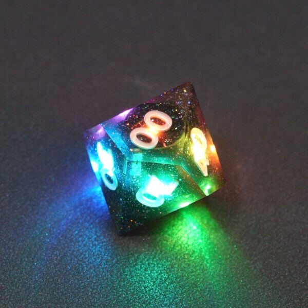 Collage of 7 lit Midnight Galaxy D00 with a rainbow of colors across each face. Midnight Galaxy colorway is a mostly translucent dark smoke black resin base packed with rainbow glitter of various sizes. The numbers or symbols are painted pearl white.