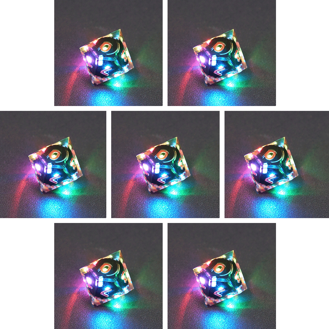 Collage of 7 lit Clear D10 with a rainbow of colors across each face. Clear colorway is fully transparent resin allowing internal circuit board to be visible. The numbers or symbols are painted metallic copper.