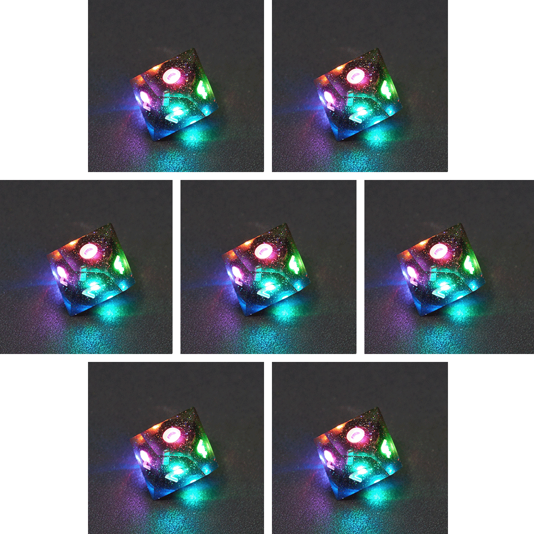 Collage of 7 lit Midnight Galaxy D10 with a rainbow of colors across each face. Midnight Galaxy colorway is a mostly translucent dark smoke black resin base packed with rainbow glitter of various sizes. The numbers or symbols are painted pearl white.