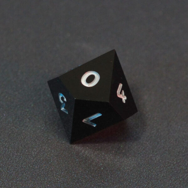 Collage of 7 lit Onyx Black D10 with a rainbow of colors across each face. Onyx Black colorway is a fully opaque black with no glitter, creating an almost matte style. The numbers or symbols are pale white.