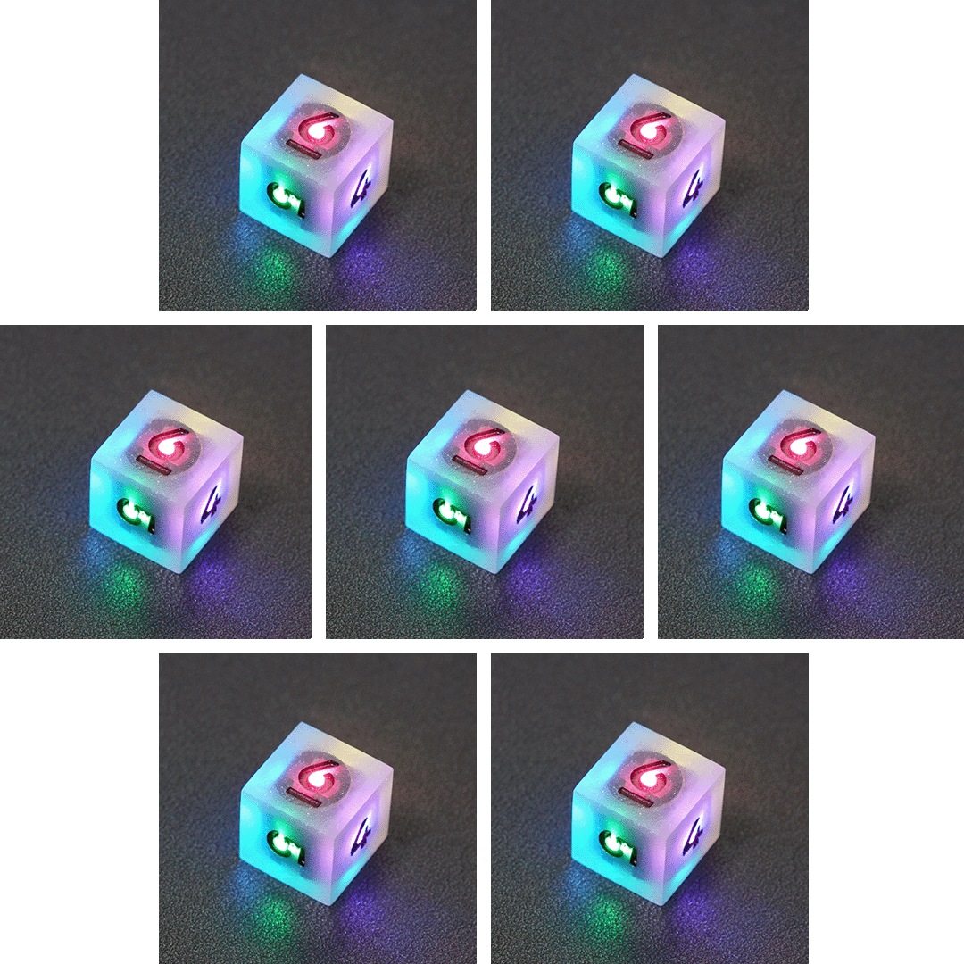 Collage of 7 lit Aurora Sky D6 with a rainbow of colors across each face. Aurora Sky colorway is a mostly translucent white resin base packed with small blue and silver glitter throughout. The numbers or symbols are painted metallic black.