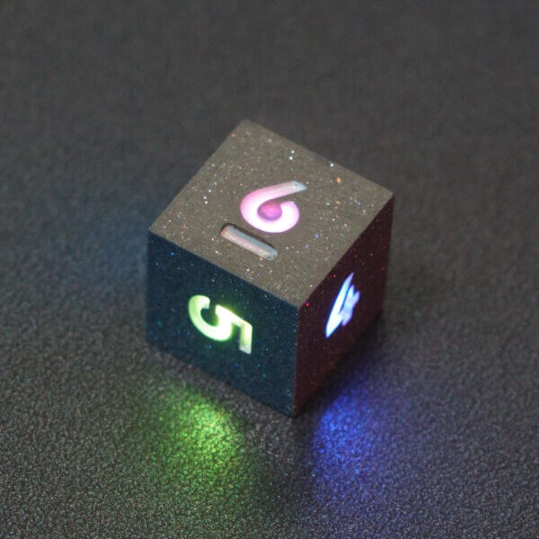 Collage of 7 lit Hematite Grey D6 with a rainbow of colors across each face. Hematite Grey colorway is a fully opaque medium tone silver resin packed with rainbow glitter of various sizes. The numbers or symbols are painted pale white.