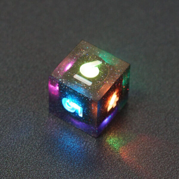 Collage of 7 lit Midnight Galaxy D6 with a rainbow of colors across each face. Midnight Galaxy colorway is a mostly translucent dark smoke black resin base packed with rainbow glitter of various sizes. The numbers or symbols are painted pearl white.