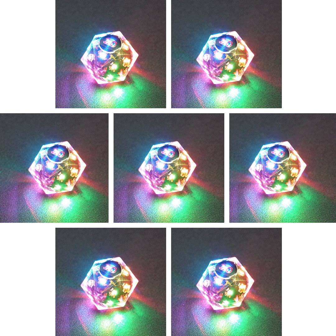 Collage of 7 lit Clear D20 with a rainbow of colors across each face. Clear colorway is fully transparent resin allowing internal circuit board to be visible. The numbers or symbols are painted metallic copper.