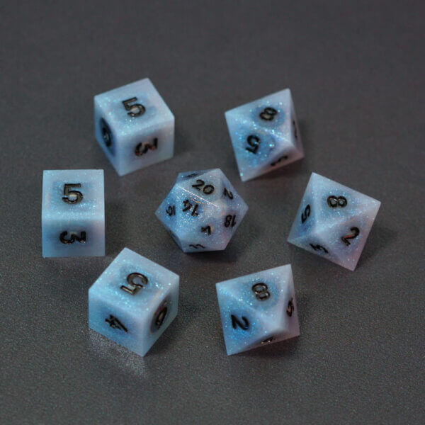 Set of 7 lit Aurora Sky dice with a rainbow of colors across all faces. Set Includes: 1 D20, 3 D8, 3 D6. Aurora Sky colorway is a mostly translucent white resin base packed with small blue and silver glitter throughout. The numbers or symbols are painted metallic black.