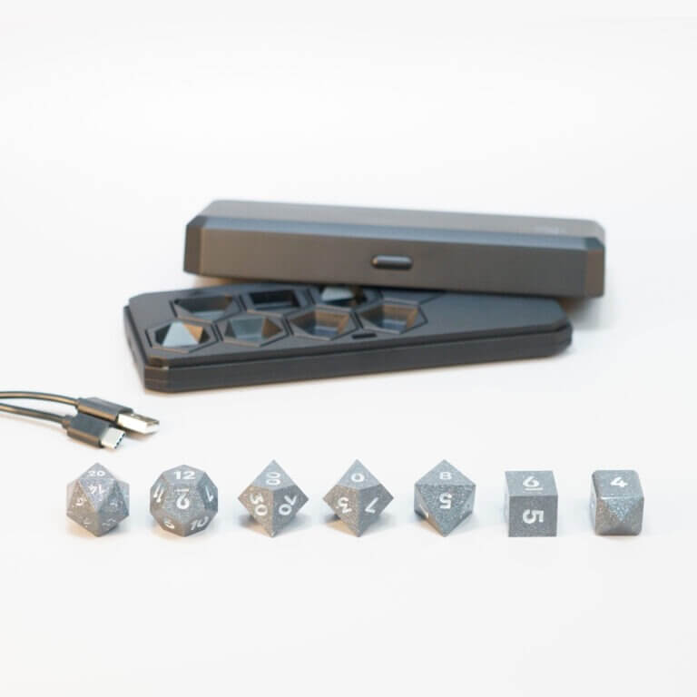 Set of 7 lit Hematite Grey dice with a rainbow of colors across all faces. Set Includes: 1 D20, 1 D12, 1 D00, 1 D10, 1 D8, 1 D6, 1 D4. Hematite Grey colorway is a fully opaque medium tone silver resin packed with rainbow glitter of various sizes. The numbers or symbols are painted pale white.