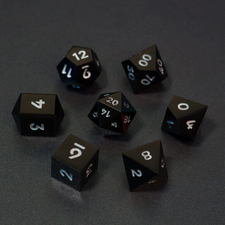 Set of 7 lit Onyx Black dice with a rainbow of colors across all faces. Set Includes: 1 D20, 1 D12, 1 D00, 1 D10, 1 D8, 1 D6, 1 D4. Onyx Black colorway is a fully opaque black resin with no glitter. The numbers or symbols are painted pale white.