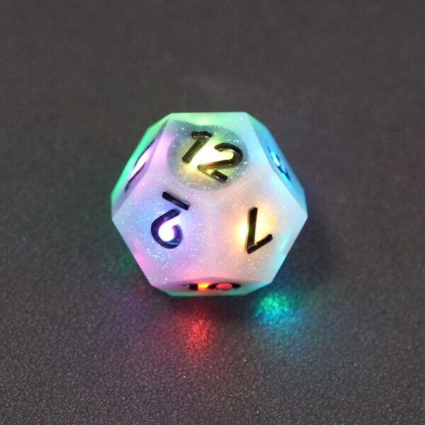 Collage of 7 lit Aurora Sky D12 with a rainbow of colors across each face. Aurora Sky colorway is a mostly translucent white resin base packed with small blue and silver glitter throughout. The numbers or symbols are painted metallic black.