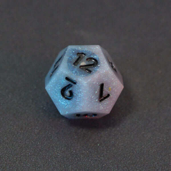 Collage of 7 lit Aurora Sky D12 with a rainbow of colors across each face. Aurora Sky colorway is a mostly translucent white resin base packed with small blue and silver glitter throughout. The numbers or symbols are painted metallic black.