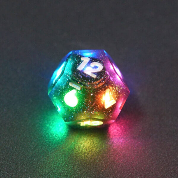 Collage of 7 lit Midnight Galaxy D12 with a rainbow of colors across each face. Midnight Galaxy colorway is a mostly translucent dark smoke black resin base packed with rainbow glitter of various sizes. The numbers or symbols are painted pearl white.