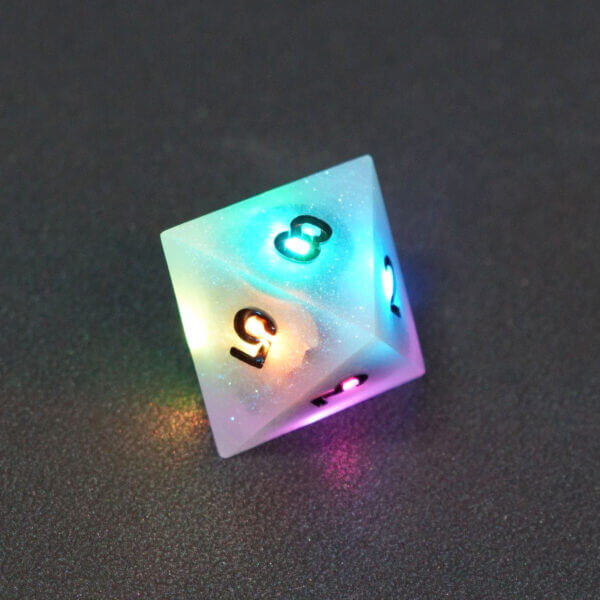 Collage of 7 lit Aurora Sky D8 with a rainbow of colors across each face. Aurora Sky colorway is a mostly translucent white resin base packed with small blue and silver glitter throughout. The numbers or symbols are painted metallic black.