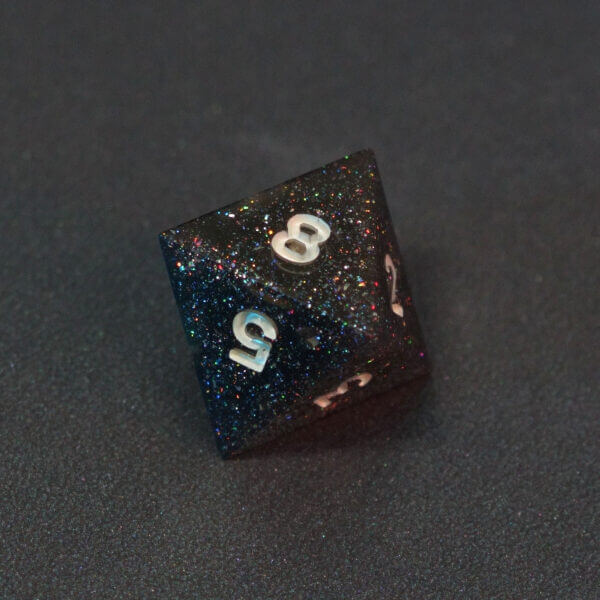 Collage of 7 lit Midnight Galaxy D8 with a rainbow of colors across each face. Midnight Galaxy colorway is a mostly translucent dark smoke black resin base packed with rainbow glitter of various sizes. The numbers or symbols are painted pearl white.