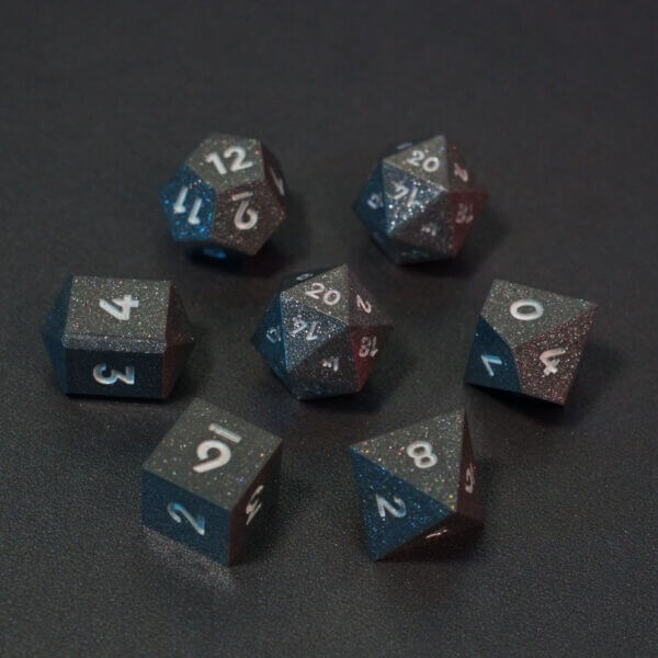Set of 7 lit Hematite Grey dice with a rainbow of colors across all faces. Set Includes: 2 D20, 1 D12, 1 D10, 1 D8, 1 D6, 1 D4. Hematite Grey colorway is a fully opaque medium tone silver resin packed with rainbow glitter of various sizes. The numbers or symbols are painted pale white.