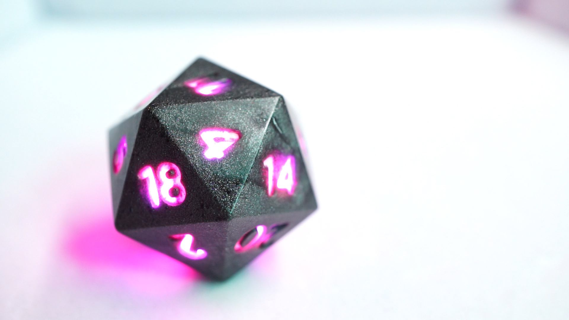 Gray D20 with numbers lit purple.
