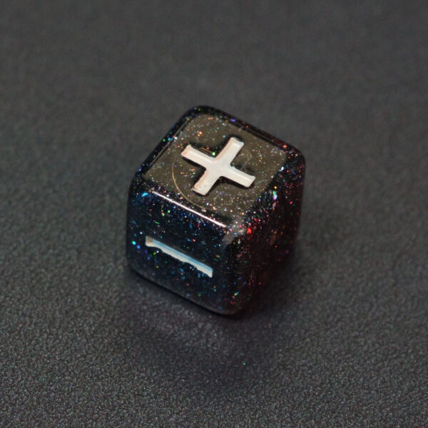 Unlit Midnight Galaxy Fudge D6. Midnight Galaxy colorway is a mostly translucent dark smoke black resin base packed with rainbow glitter of various sizes. The numbers or symbols are painted pearl white.