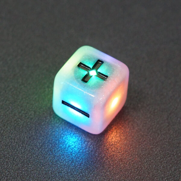 Lit Aurora Sky Fudge D6 with a rainbow of colors across each face. Aurora Sky colorway is a mostly translucent white resin base packed with small blue and silver glitter throughout. The numbers or symbols are painted metallic black.