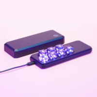 Lit Midnight Galaxy Power set placed inside a Large Charging Case with a USB cable plugged into the side of the case.
