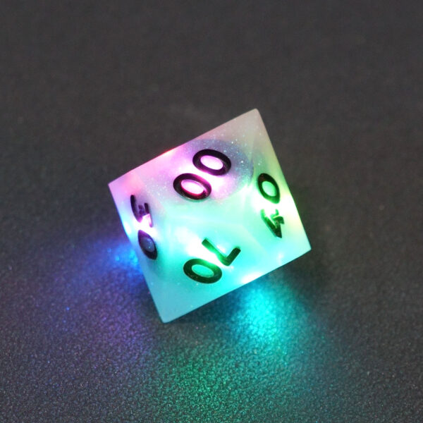 Lit Aurora Sky D00 with a rainbow of colors across each face. Aurora Sky colorway is a mostly translucent white resin base packed with small blue and silver glitter throughout. The numbers or symbols are painted metallic black.