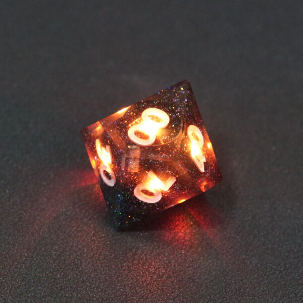 Lit Midnight Galaxy D00 with orange colors across each face. Midnight Galaxy colorway is a mostly translucent dark smoke black resin base packed with rainbow glitter of various sizes. The numbers or symbols are painted pearl white.
