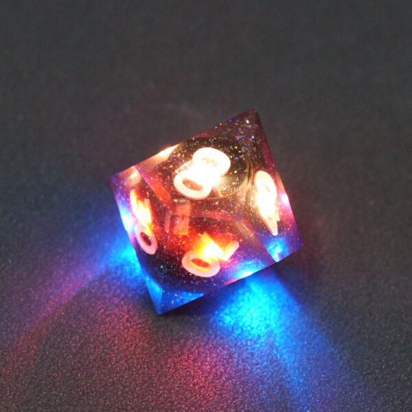 Lit Midnight Galaxy D00 with red and blue colors across each face. Midnight Galaxy colorway is a mostly translucent dark smoke black resin base packed with rainbow glitter of various sizes. The numbers or symbols are painted pearl white.