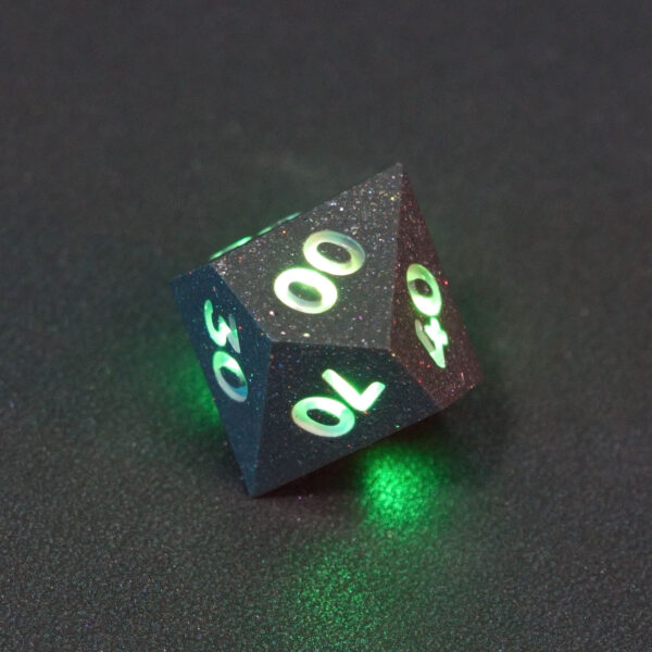 Lit Hematite Grey D00 with green colors across each face. Hematite Grey colorway is a fully opaque medium tone silver resin packed with rainbow glitter of various sizes. The numbers or symbols are painted pale white.
