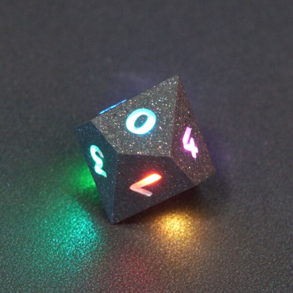 Lit Hematite Grey D10 with a rainbow of colors across each face. Hematite Grey colorway is a fully opaque medium tone silver resin packed with rainbow glitter of various sizes. The numbers or symbols are painted pale white.