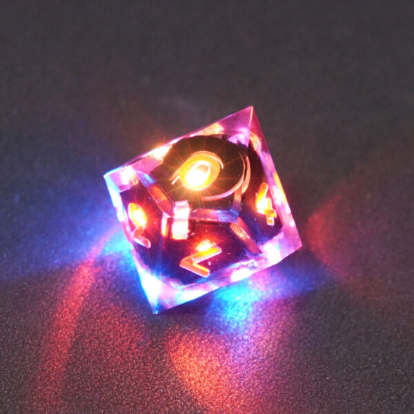 Lit Clear D10 with a rainbow of colors across each face. Clear colorway is fully transparent resin allowing internal circuit board to be visible. The numbers or symbols are painted metallic copper.