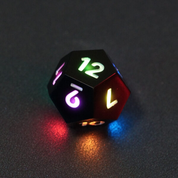 Lit Onyx Black D12 with a rainbow of colors across each face. Onyx Black colorway is a fully opaque black resin with no glitter. The numbers or symbols are painted pale white.