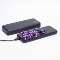 Lit Onyx Black Board Gamer set placed inside a Large Charging Case with a USB cable plugged into the side of the case.