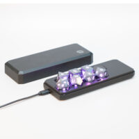 Lit Hematite Gray RPG set placed inside a Large Charging Case with a USB cable plugged into the side of the case.