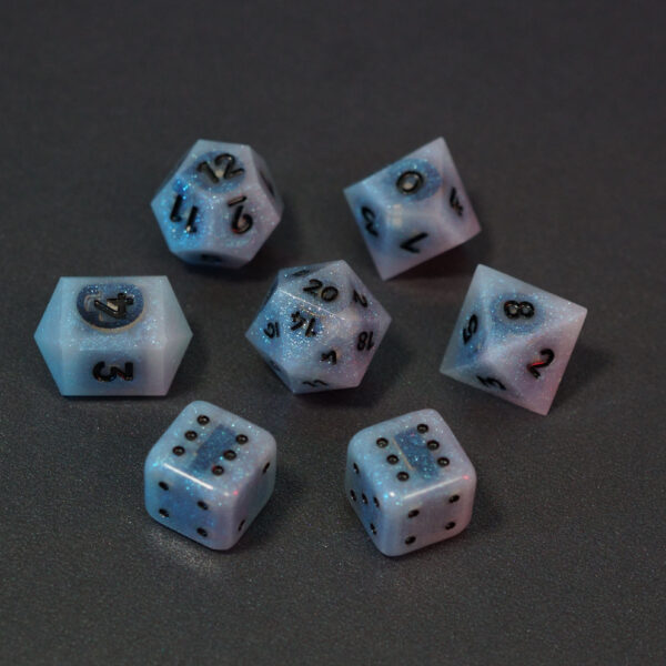 Set of 7 unlit Aurora Sky dice. Set Includes: 1 D20, 1 D12, 1 D10, 1 D8, 2 Pipped D6, 1 D4. Aurora Sky colorway is a mostly translucent white resin base packed with small blue and silver glitter throughout. The numbers or symbols are painted metallic black.
