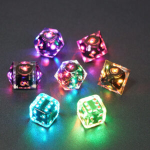 Set of 7 lit Clear dice with a rainbow of colors across all faces. Set Includes: 1 D20, 1 D12, 1 D10, 1 D8, 2 Pipped D6, 1 D4. Clear colorway is fully transparent resin allowing internal circuit board to be visible. The numbers or symbols are painted metallic copper.