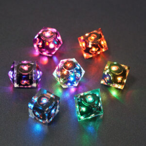 Set of 7 lit Clear dice with a rainbow of colors across all faces. Set Includes: 1 D20, 1 D12, 1 D00, 1 D10, 1 D8, 1 D6, 1 D4. Clear colorway is fully transparent resin allowing internal circuit board to be visible. The numbers or symbols are painted metallic copper.