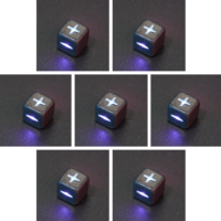 Collage of 7 lit Hematite Grey Fudge D6 with a rainbow of colors across each face. Hematite Grey colorway is a fully opaque medium tone silver resin packed with rainbow glitter of various sizes. The numbers or symbols are painted pale white.