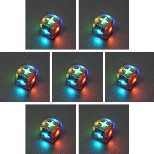 Collage of 7 lit Midnight Galaxy Fudge D6 with a rainbow of colors across each face. Midnight Galaxy colorway is a mostly translucent dark smoke black resin base packed with rainbow glitter of various sizes. The numbers or symbols are painted pearl white.