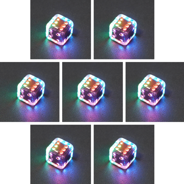 Collage of 7 lit Clear Pipped D6 with a rainbow of colors across each face. Clear colorway is fully transparent resin allowing internal circuit board to be visible. The numbers or symbols are painted metallic copper.