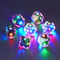 Set of 7 lit Clear dice with a rainbow of colors across all faces. Set Includes: 2 D20, 1 D12, 1 D10, 1 D8, 1 D6, 1 D4. Clear colorway is fully transparent resin allowing internal circuit board to be visible. The numbers or symbols are painted metallic copper.