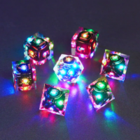 Set of 7 lit Clear dice with a rainbow of colors across all faces. Set Includes: 1 D20, 3 D8, 3 D6. Clear colorway is fully transparent resin allowing internal circuit board to be visible. The numbers or symbols are painted metallic copper.