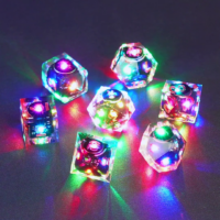 Set of 7 lit Clear dice with a rainbow of colors across all faces. Set Includes: 1 D20, 1 D12, 1 D00, 1 D10, 1 D8, 1 D6, 1 D4. Clear colorway is fully transparent resin allowing internal circuit board to be visible. The numbers or symbols are painted metallic copper.