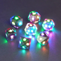 Set of 7 lit Midnight Galaxy dice with a rainbow of colors across all faces. Set Includes: 2 D20, 1 D12, 1 D10, 1 D8, 1 D6, 1 D4. Midnight Galaxy colorway is a mostly translucent dark smoke black resin base packed with rainbow glitter of various sizes. The numbers or symbols are painted pearl white.