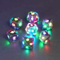 Set of 7 lit Midnight Galaxy dice with a rainbow of colors across all faces. Set Includes: 1 D20, 1 D12, 1 D00, 1 D10, 1 D8, 1 D6, 1 D4. Midnight Galaxy colorway is a mostly translucent dark smoke black resin base packed with rainbow glitter of various sizes. The numbers or symbols are painted pearl white.