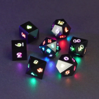 Set of 7 lit Onyx Black dice with a rainbow of colors across all faces. Set Includes: 1 D20, 1 D12, 1 D00, 1 D10, 1 D8, 1 D6, 1 D4. Onyx Black colorway is a fully opaque black resin with no glitter. The numbers or symbols are painted pale white.